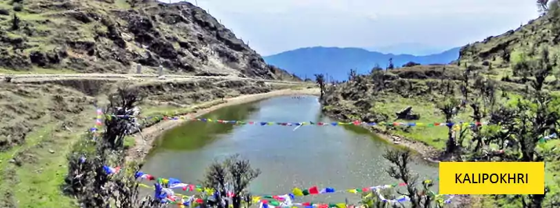 the beautiful and sacred lake of kalipokhri with prayer flags over the lake waters